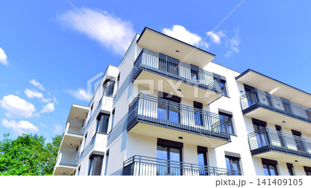 European residential architecture harmonizing with nature. Eco-friendly living in city with greens. Eco apartment building saving energy and fresh air concept. European residential architecture harmonizing with nature. Eco-friendly living in city with greens. Eco apartment building saving energy and fresh air concept. 141409105