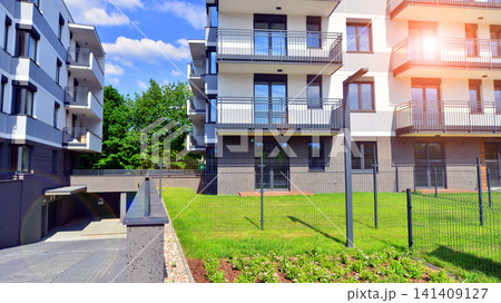 European residential architecture harmonizing with nature. Eco-friendly living in city with greens. Eco apartment building saving energy and fresh air concept. European residential architecture harmonizing with nature. Eco-friendly living in city with greens. Eco apartment building saving energy and fresh air concept. 141409127