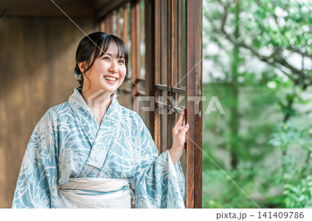 日本家屋の縁側にいる浴衣姿のアジア人女性 日本家屋の縁側にいる浴衣姿のアジア人女性 141409786