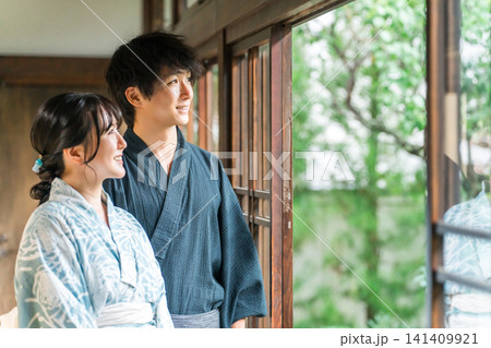 日本家屋の縁側で庭を眺める浴衣姿の夫婦,カップル 日本家屋の縁側で庭を眺める浴衣姿の夫婦,カップル 141409921