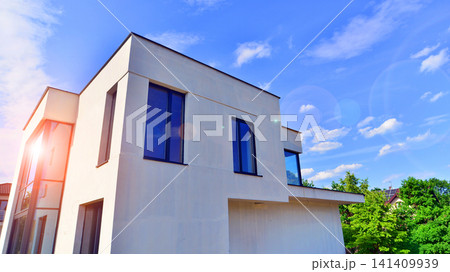 Modern rectangular minimalist house for familie. Exterior view of two story house with modern design and having black glass windows. Exterior view of modern style or houses for living. Modern rectangular minimalist house for familie. Exterior view of two story house with modern design and having black glass windows. Exterior view of modern style or houses for living. 141409939