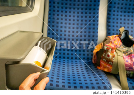 Small trash bin mounted between seats inside German S-Bahn train carriage Small trash bin mounted between seats inside German S-Bahn train carriage 141410396