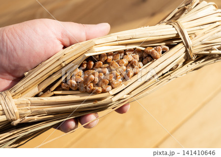 稲わらに包まれた発酵食品の納豆(ワラツト)を持つ男性 稲わらに包まれた発酵食品の納豆(ワラツト)を持つ男性 141410646