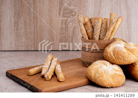 French baguettes. Fresh crispbread. Bread background. Different breed on wooden background. French baguettes. Fresh crispbread. Bread background. Different breed on wooden background. 141411289