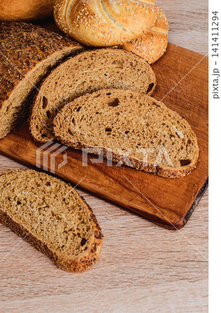 French baguettes. Fresh crispbread. Bread background. Different breed on wooden background. French baguettes. Fresh crispbread. Bread background. Different breed on wooden background. 141411294