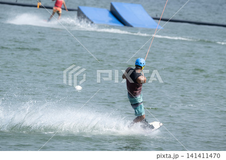 Cable Wakeboarder Riding on Lake in Summer. Cable Wakeboarder Riding on Lake in Summer. 141411470