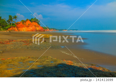 Aerial view of coastal rock formations rising from the sea with crashing waves and sandy beach in Indonesia Aerial view of coastal rock formations rising from the sea with crashing waves and sandy beach in Indonesia 141411699