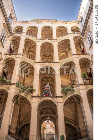 Naples, italy. December 29, 2024. Palazzo dello spagnolo featuring its open staircase, baroque architecture, and ornate details in naples, italy, with a christmas tree Naples, italy. December 29, 2024. Palazzo dello spagnolo featuring its open staircase, baroque architecture, and ornate details in naples, italy, with a christmas tree 141411888