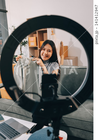 Woman recording live stream preparing packages for online selling Woman recording live stream preparing packages for online selling 141412947