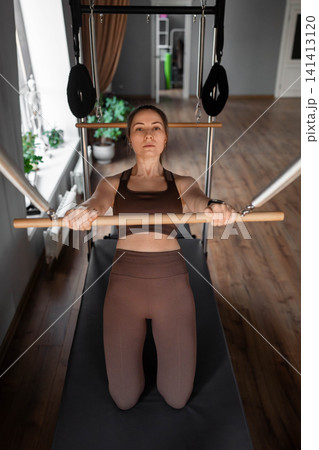Elegant pilates pair performing synchronized deep stretches using reformer beds in bright wood-floored studio. Synchronized, deep stretch, reformer, studio, wood floor Elegant pilates pair performing synchronized deep stretches using reformer beds in bright wood-floored studio. Synchronized, deep stretch, reformer, studio, wood floor 141413120