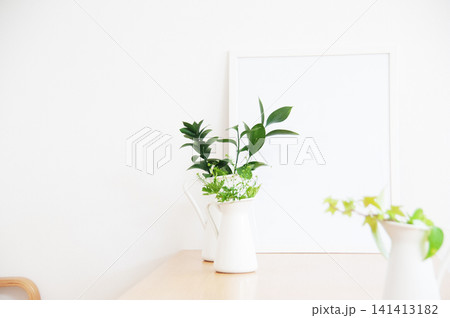 白壁と木のテーブルに飾られた白い花瓶の観葉植物 白壁と木のテーブルに飾られた白い花瓶の観葉植物 141413182