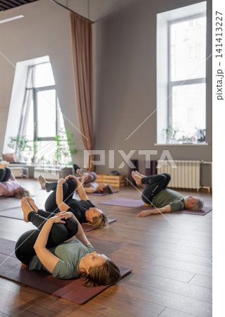 Woman, instructor and yoga class for fitness, stretching or back at wellness retreat. Yogi, group exercise and people with trainer at resort for balance, healing and health with side bend outdoor Woman, instructor and yoga class for fitness, stretching or back at wellness retreat. Yogi, group exercise and people with trainer at resort for balance, healing and health with side bend outdoor 141413227