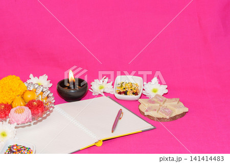 Diwali chopda pujan concept with open notebook sweets and diya Diwali chopda pujan concept with open notebook sweets and diya 141414483