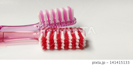 A side-view macro shot featuring a pink and purple toothbrush. A side-view macro shot featuring a pink and purple toothbrush. 141415133