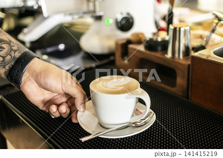 Barista making a Cappuccino coffee in modern coffeeshop with professional equipment Barista making a Cappuccino coffee in modern coffeeshop with professional equipment 141415219