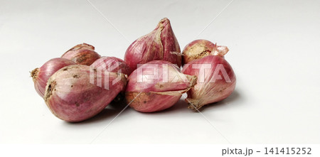 A cluster of fresh, raw shallots against a white background. 141415252