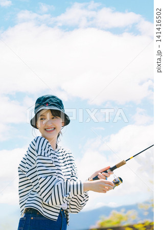 趣味の釣りを楽しむ若い女性 趣味の釣りを楽しむ若い女性 141416502