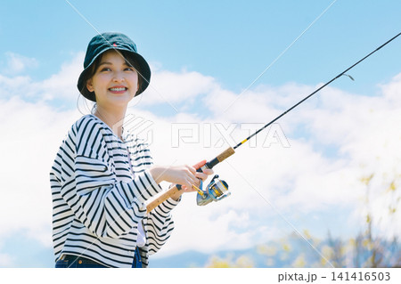 趣味の釣りを楽しむ若い女性 141416503