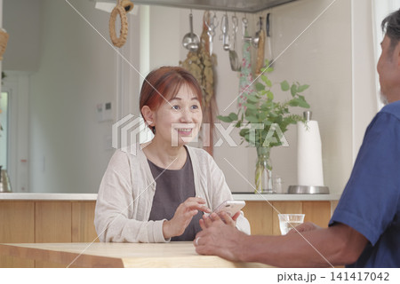 スマホで老後のことを考えるシニア夫婦 スマホで老後のことを考えるシニア夫婦 141417042