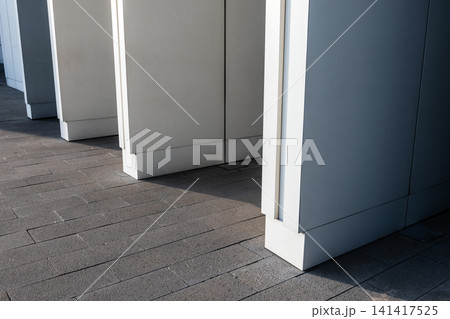 Minimalist modern building exterior with a row of white columns Minimalist modern building exterior with a row of white columns 141417525