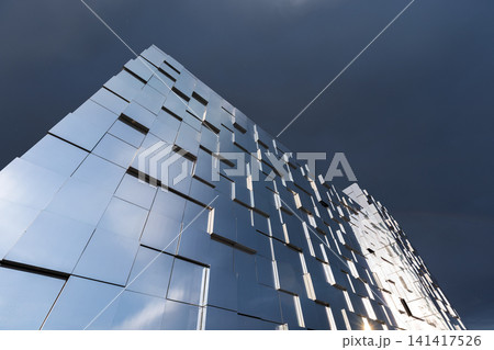 Low-angle view of a modern reflective building facade Low-angle view of a modern reflective building facade 141417526