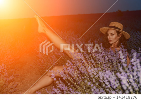 Lavender woman hat, woman posing with one leg raised in a lavender field during sunset, tranquil nature lifestyle photography 141418276