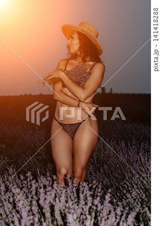 Woman lavender field straw hat posing in nature during golden hour sunset while holding fresh flowers for lifestyle summer photography Woman lavender field straw hat posing in nature during golden hour sunset while holding fresh flowers for lifestyle summer photography 141418288