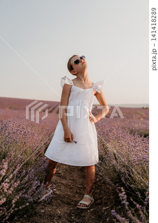 Girl child summer, young girl posing in white dress in a beautiful lavender field at sunset with copy space for text 141418289