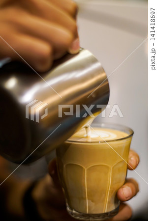 Barista Making Creamy Latte by Pouring Steamed Milk into Glass Barista Making Creamy Latte by Pouring Steamed Milk into Glass 141418697