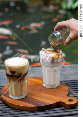 Espresso Poured into Iced Milk Coffee Served in Outdoor Cafe 141418709