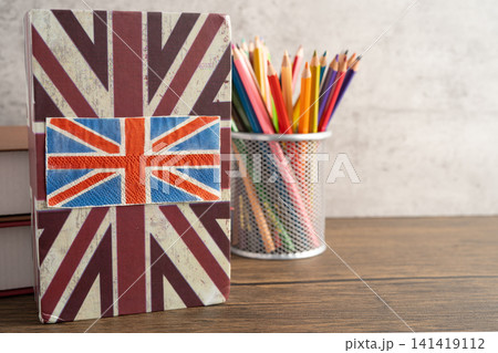 UK flag with graduate hat on english language book. UK flag with graduate hat on english language book. 141419112