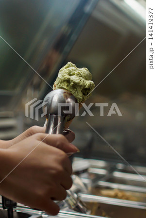 Matcha ice cream scoop close up in gelato shop dessert preparation Matcha ice cream scoop close up in gelato shop dessert preparation 141419377