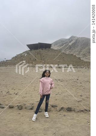 Girl in front of ancient pyramid at Caral ruins Girl in front of ancient pyramid at Caral ruins 141420008