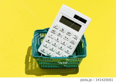 黄色背景に計算機と買い物カゴ　節約や家計のイメージ素材 141420081