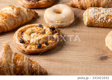 Assorted fresh pastries on wooden table 141421032