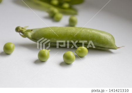 Fresh green pea pod with organic peas isolated on white background. Close up view of healthy legumes, raw vegetable ingredient, natural harvest, vegan nutrition, vegetarian eating, diet concept. 141421310