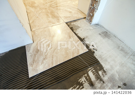 Ceramic tiles and tools for tiler. Floor tiles installation. Home improvement, renovation - ceramic tile floor adhesive, mortar, level 141422036