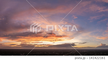 Amazing sunset skyscape. Evening sky with bright colorful orange and yellow clouds over dark landscape 141422161
