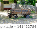 Old wooden cart on wheels against a fence 141422784