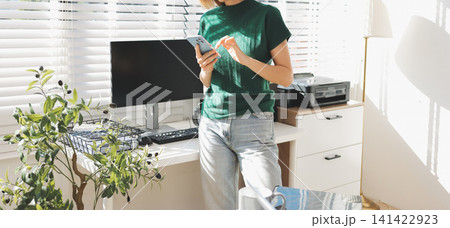 Business asian woman using mobile phone during checking an email or social media on internet. accounting financial concept. 141422923