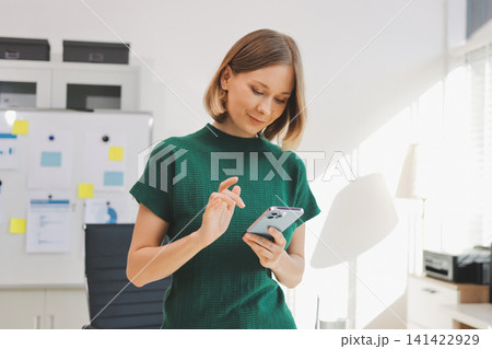 Closeup image of a businesswoman using mobile phone in office Closeup image of a businesswoman using mobile phone in office 141422929