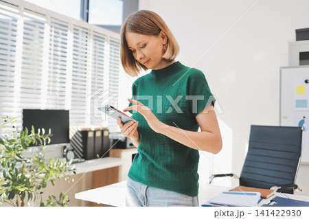 Closeup image of a businesswoman using mobile phone in office Closeup image of a businesswoman using mobile phone in office 141422930