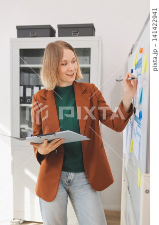 Woman smiling to herself as she works in an office Woman smiling to herself as she works in an office 141422941