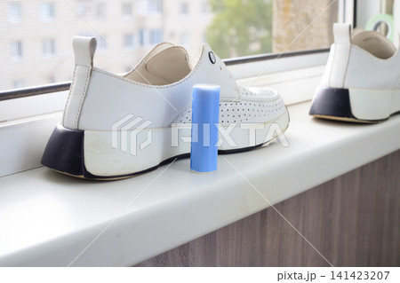 Shoes cleaning stick and white sport shoes. White sneakers maintenance and stain remover product background. Blue detergent bar for laundry care Shoes cleaning stick and white sport shoes. White sneakers maintenance and stain remover product background. Blue detergent bar for laundry care 141423207