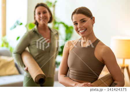 Fit trainer smiling while standing with student Fit trainer smiling while standing with student 141424375