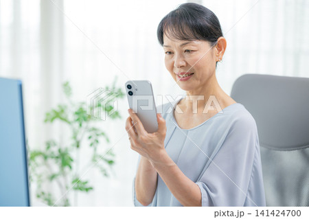 スマホを操作するシニア女性 141424700