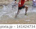 川を激しく走るランナーの足元と水しぶき 141424734