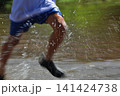 浅瀬を元気いっぱいに走る子供の足元と激しい水しぶき 141424738