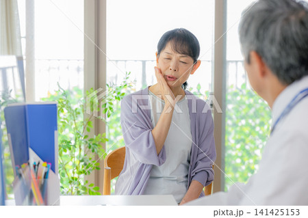 診察を受けるシニア女性と医者 診察を受けるシニア女性と医者 141425153