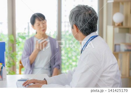 診察を受けるシニア女性と医者 診察を受けるシニア女性と医者 141425170